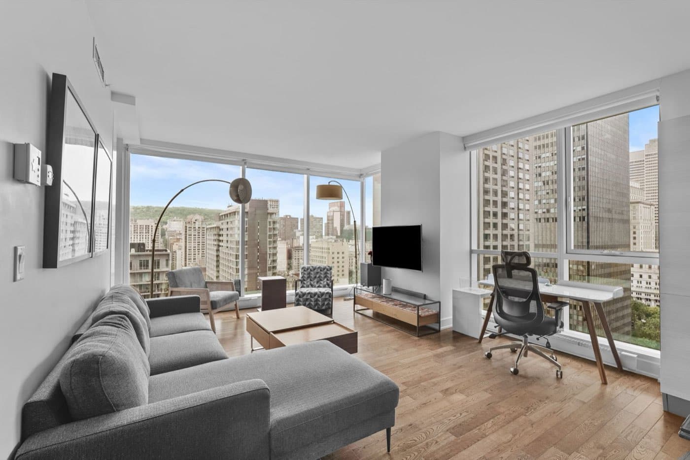 Photographie immobilière d’un salon lumineux avec vue sur Montréal